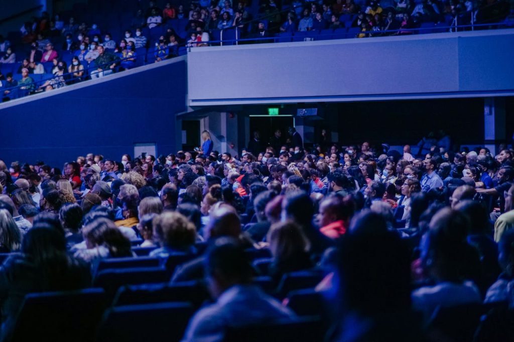 pexels photo 15448073 A crowded conference hall with diverse audience attentively listening to a speaker.