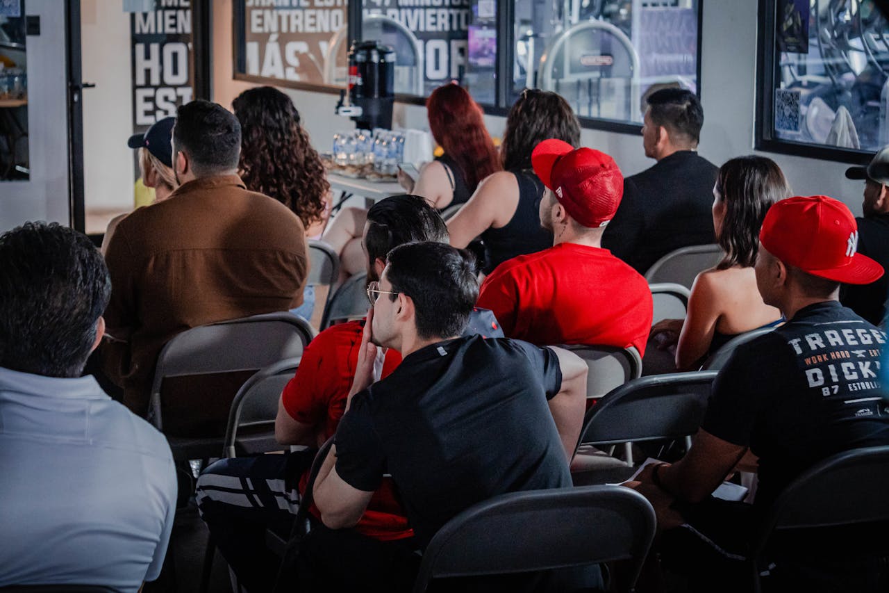 A diverse audience attentively participates in an indoor seminar setting, highlighting education and engagement.